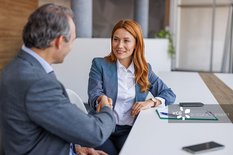 女商人与男商人在成功交易后握手图片素材