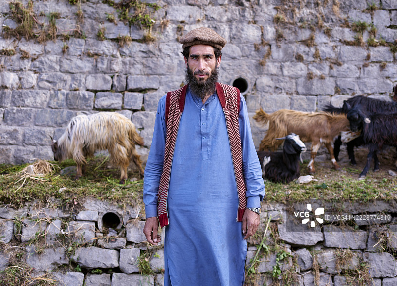 巴基斯坦农民在市场上与山羊合影图片素材