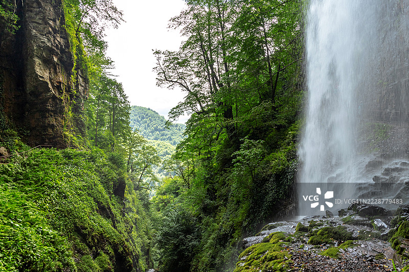 阿布哈兹巨型维利坎瀑布峡谷。喷涌溪流附近的美丽山谷风景。图片素材