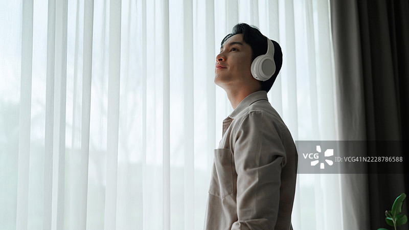 亚洲男子在家听音乐图片素材