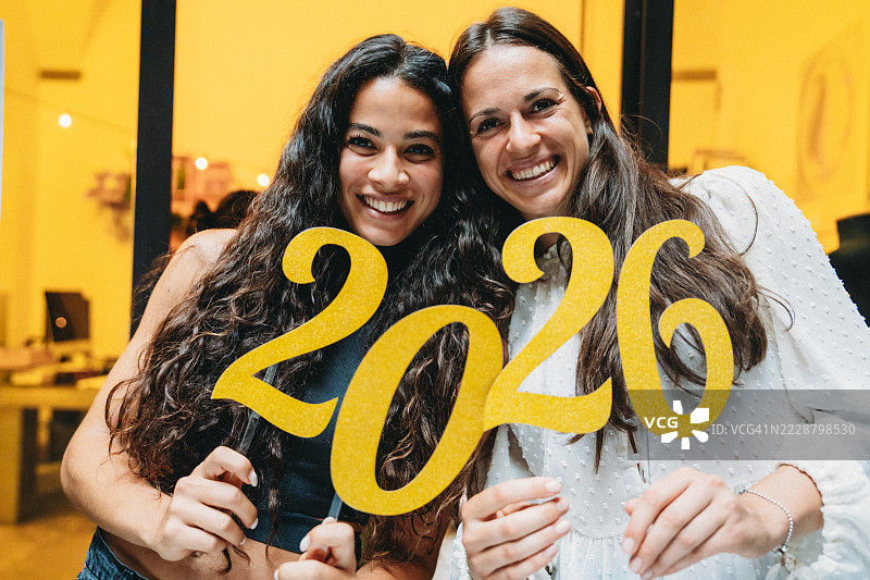 两位年轻女性手持2026标志，面带微笑图片素材
