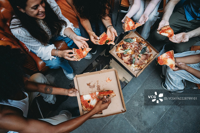 朋友们在轻松聚会中分享披萨图片素材