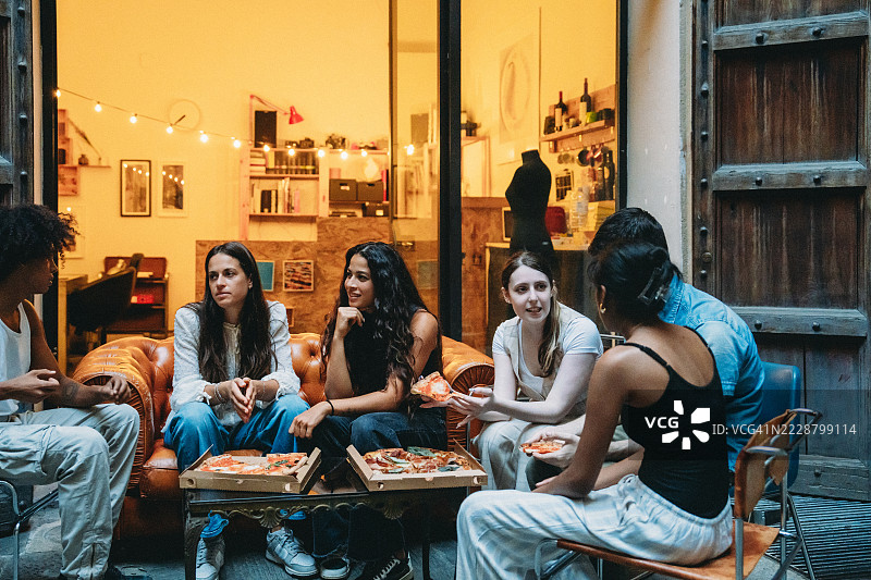 年轻人们在户外享受比萨和交谈图片素材