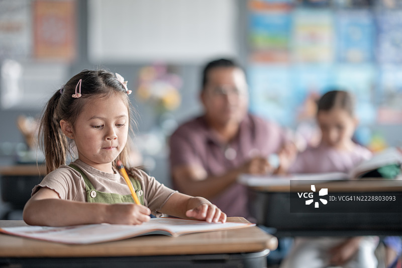 年轻女孩在教室里与同学和老师一起学习图片素材
