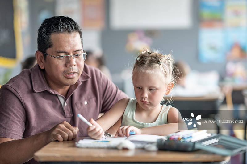 教师在教室环境中协助年轻学生完成课业图片素材