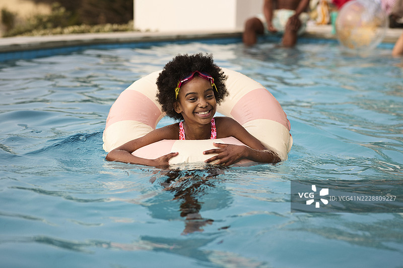 快乐的女孩在游泳池里游泳图片素材