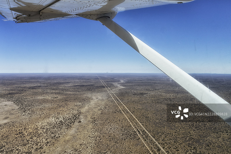 沙漠中笔直的长土路俯瞰图，周围有灌木丛图片素材