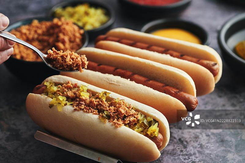 变种热狗配烤洋葱、泡菜酱、芥末、番茄酱和各种配料图片素材