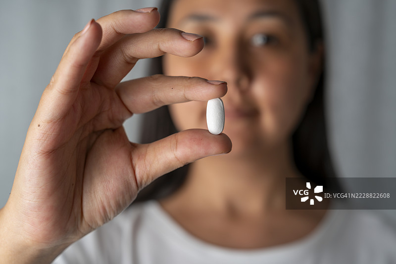 女人手中握着白色药丸图片素材