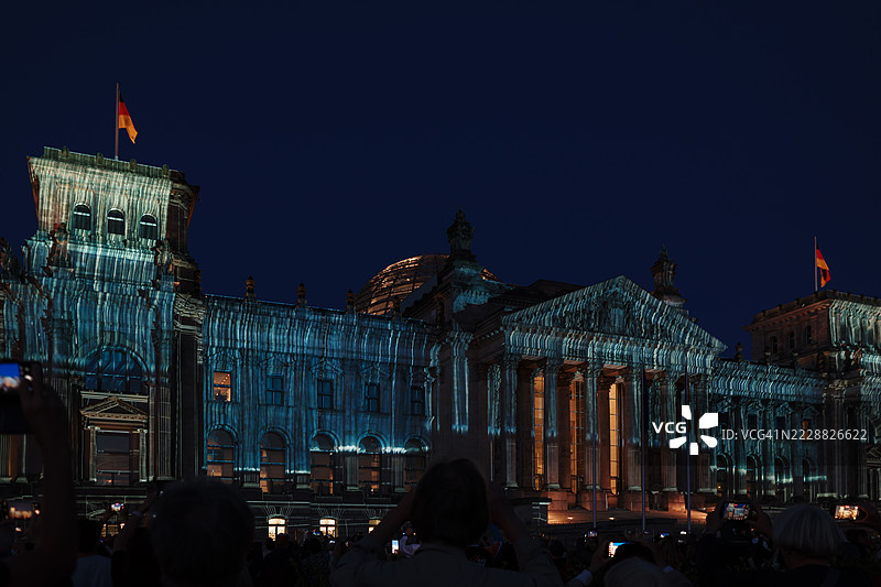 柏林国会大厦被照亮，以纪念“包裹国会大厦”艺术项目的30周年。图片素材