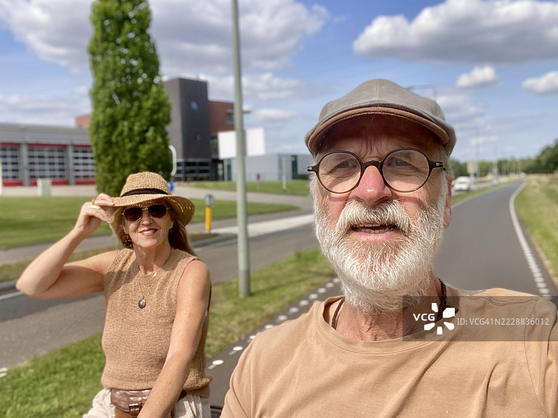 老年夫妇骑电动自行车在乡间旅行。图片素材