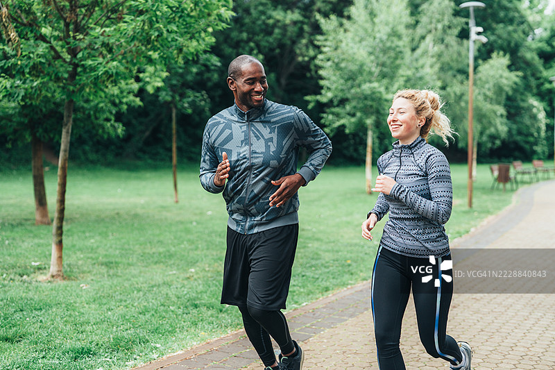 户外有氧训练。快乐的运动情侣在大自然中一起奔跑，享受乐趣。图片素材