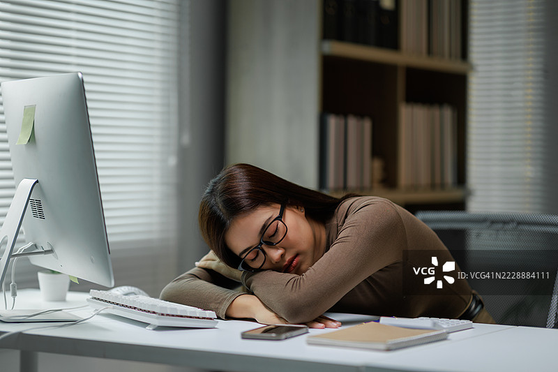 年轻专业人士在办公桌上睡觉图片素材