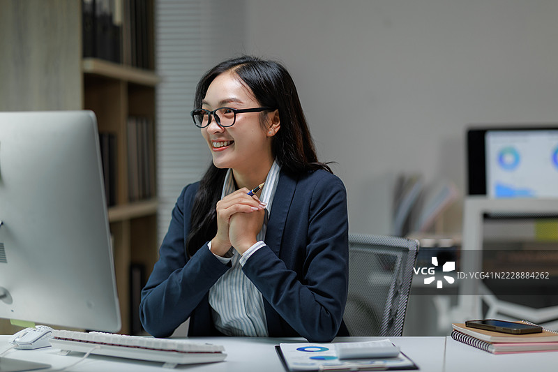 兴奋的女商人在办公室使用电脑工作图片素材