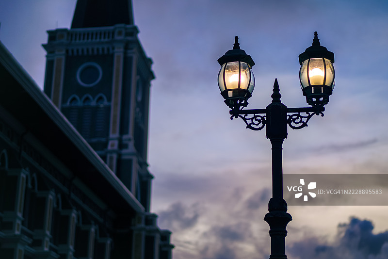 夜空中电灯柱与背景中的罗马天主教教堂图片素材
