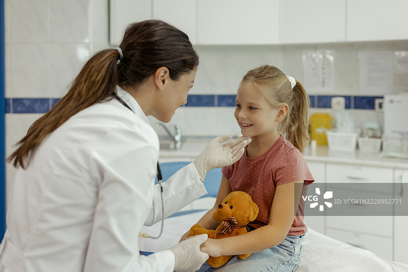 积极的医生和微笑的儿童患者在儿科医院病房内图片素材