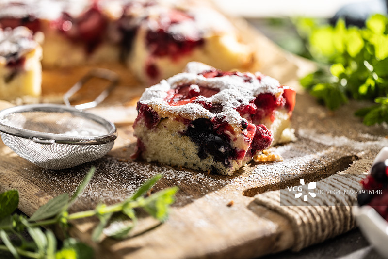 水果海绵蛋糕，上面撒有草莓、蓝莓、糖粉和薄荷叶图片素材