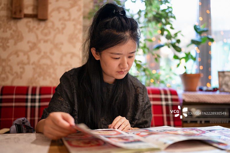一位女性正在餐厅里查看菜单图片素材