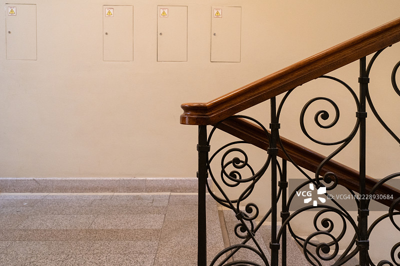 优雅的楼梯扶手，配有华丽的铁艺和木质扶手图片素材