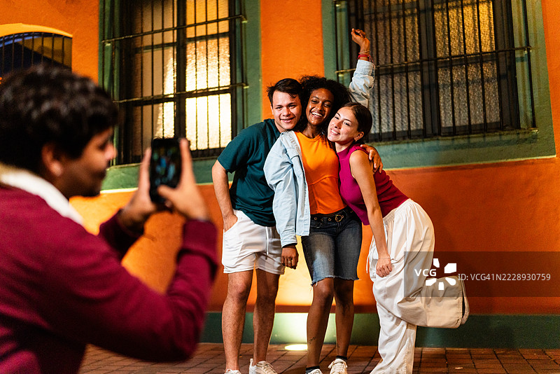 年轻朋友们在户外摆姿势拍照图片素材