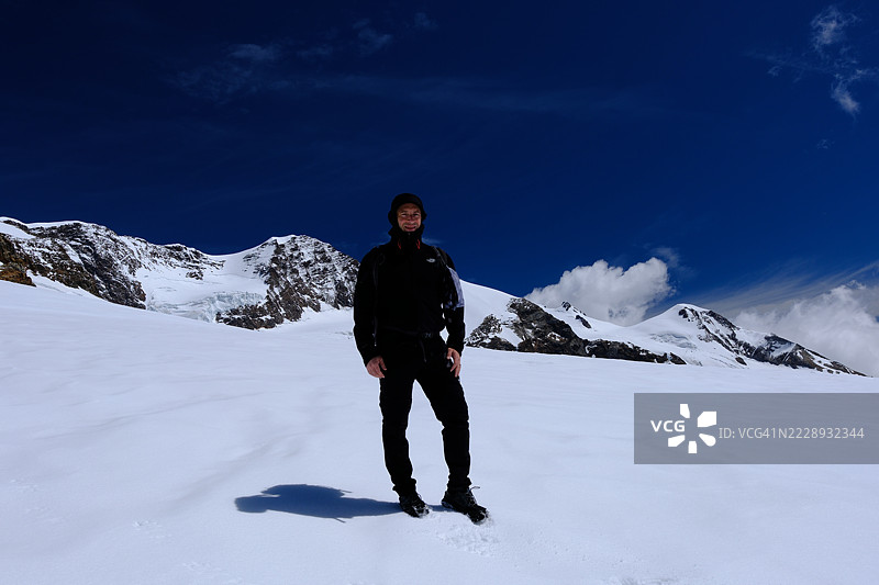 雪地徒步者 - 男子在蓝天下徒步于山峦之间图片素材