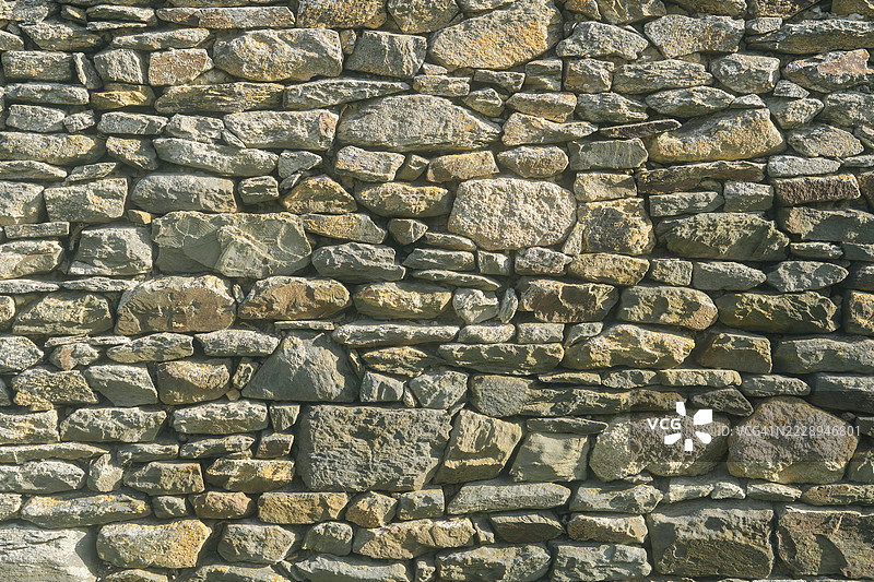 前景中没有人的石块墙壁外观正面视图。图片素材