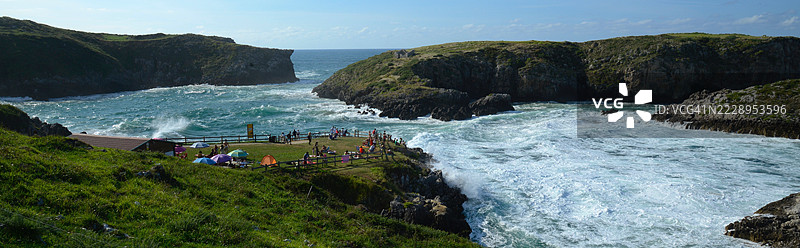 高角度俯瞰悬崖边海边的人们，天空背景，西班牙阿斯图里亚斯公国兰尼斯图片素材