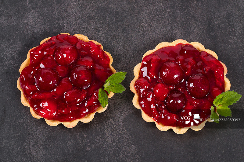 两个樱桃塔。深灰色背景。俯视图图片素材