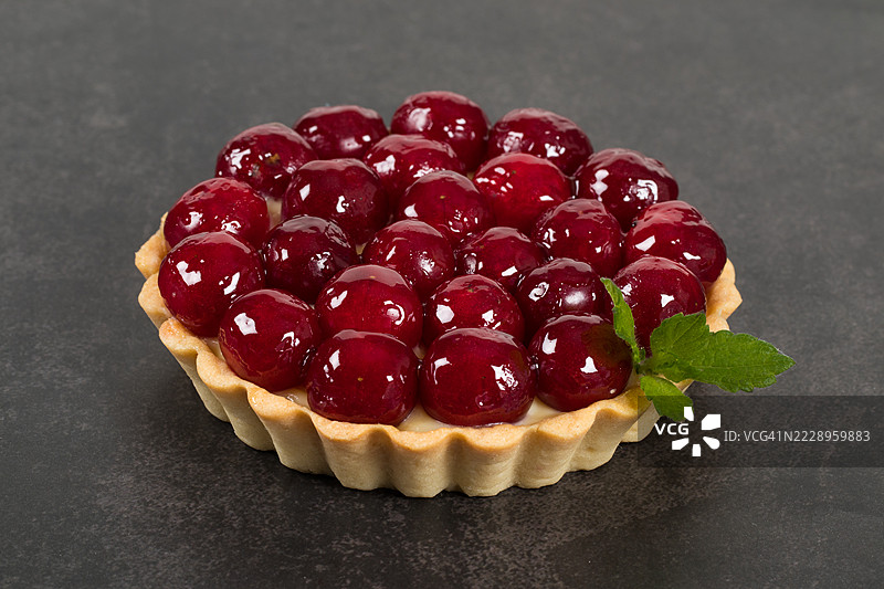 樱桃挞，配薄荷。深灰色背景。特写。图片素材