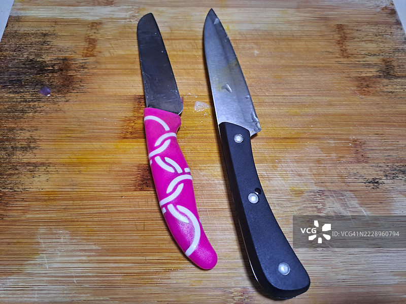 两把刀放在木质切菜板上图片素材