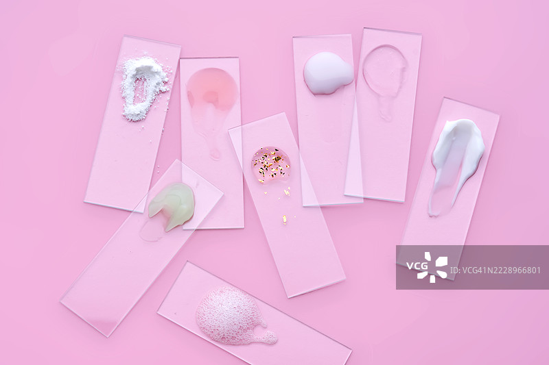 粉色背景上摆放着各种化妆品、面霜和精华液的幻灯片图片素材