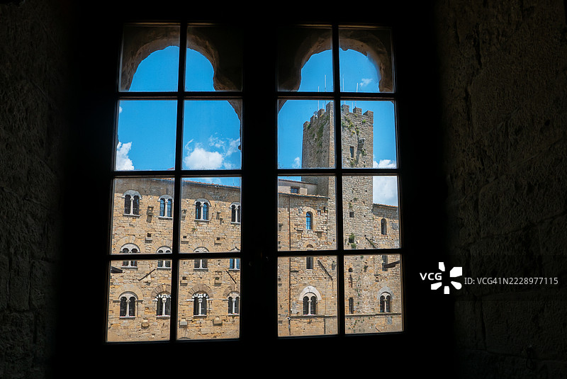 通过宫殿的窗户看到的沃尔泰拉风景。图片素材
