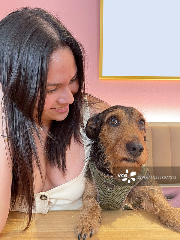 在宠物友好的咖啡馆里，和小狗一起享受温馨时刻，侧目而视，享受美好陪伴。图片素材