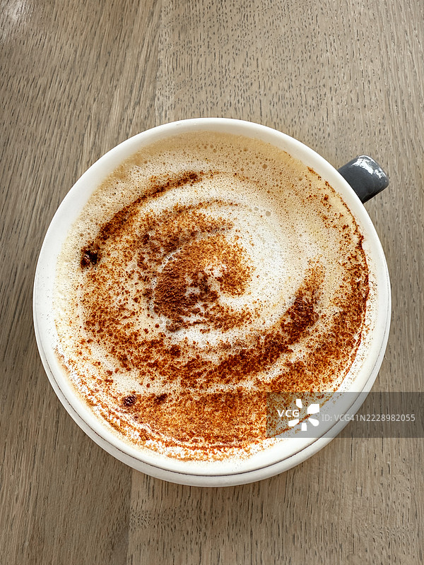 木质背景上的拿铁咖啡杯图片素材