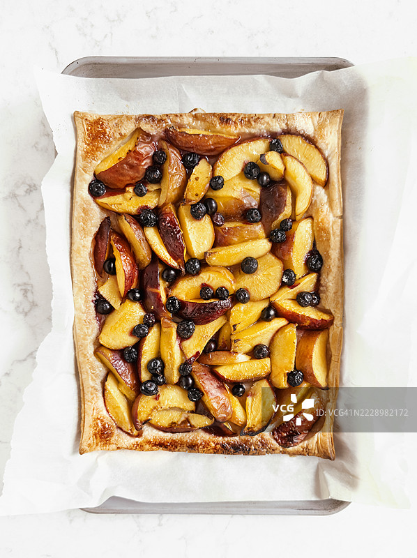 桃子和蓝莓酥皮甜点放在烘焙纸上图片素材