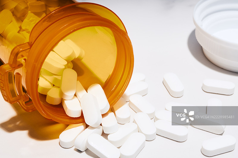 处方瓶中的药丸洒落一地图片素材