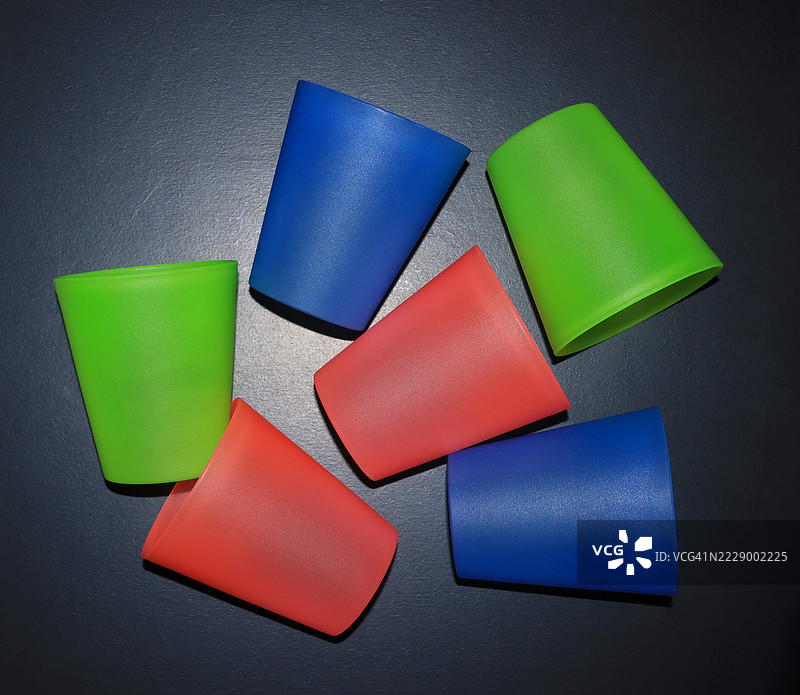 黑色背景上的多彩塑料饮水杯图片素材