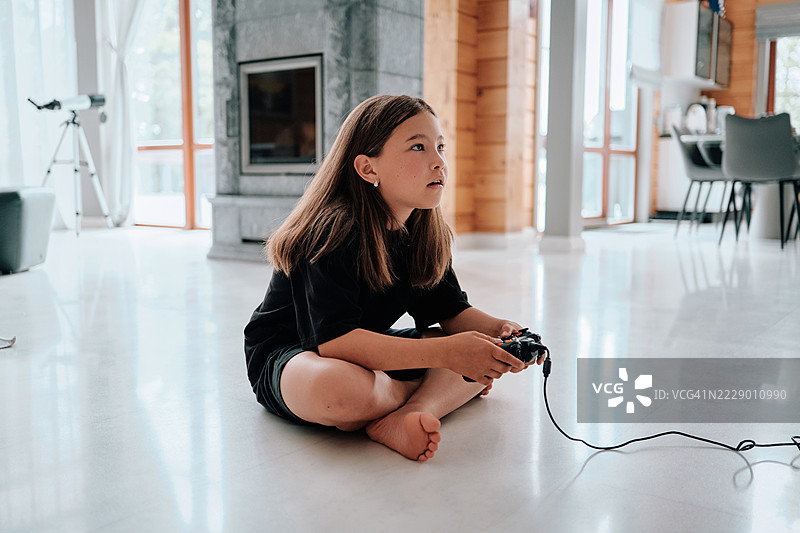 一个女孩正在用操纵杆在游戏机上玩视频游戏。图片素材