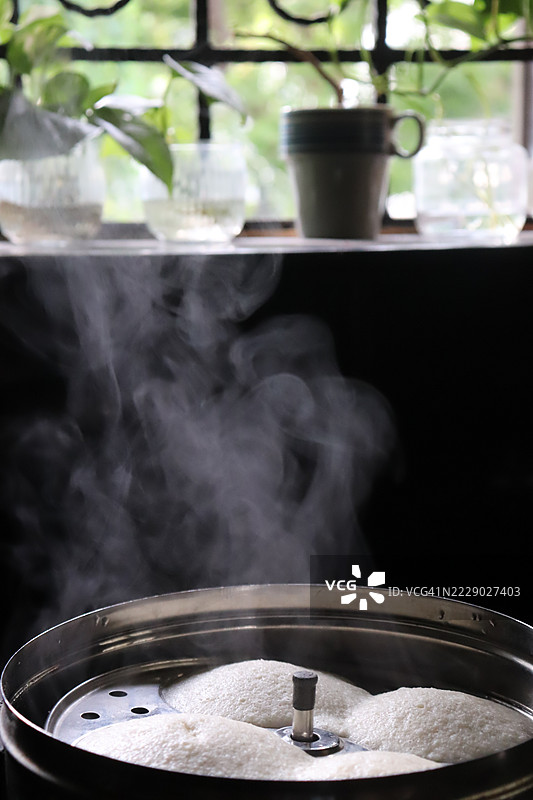 热腾腾的印度蒸饼在厨房窗台的蒸锅里/植物/早晨场景/早餐图片素材
