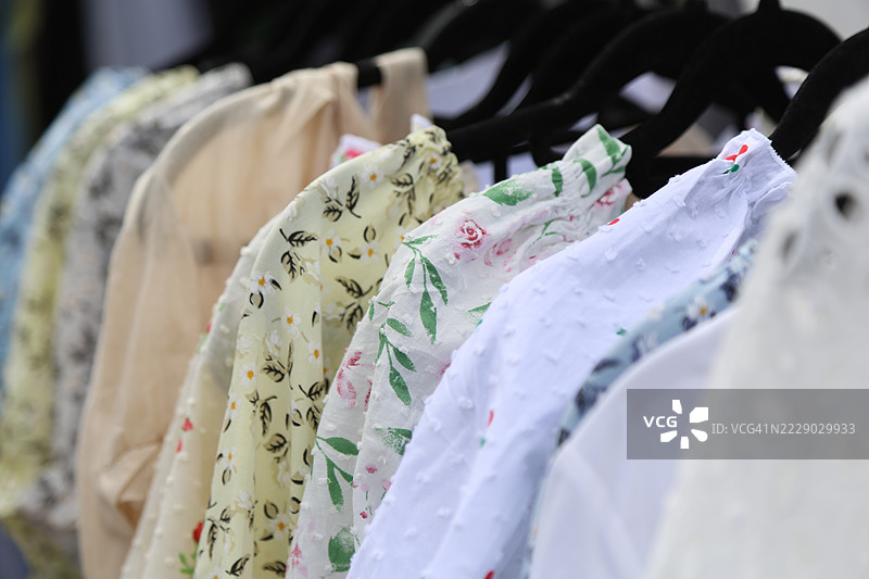全框白色夏季棉质连衣裙、上衣和衬衫挂在衣架上图片素材