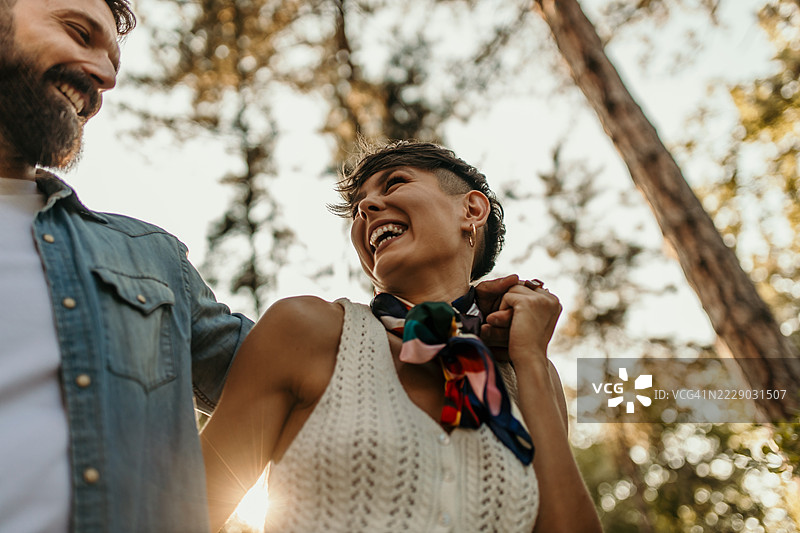 快乐的情侣在森林中散步并欢笑图片素材
