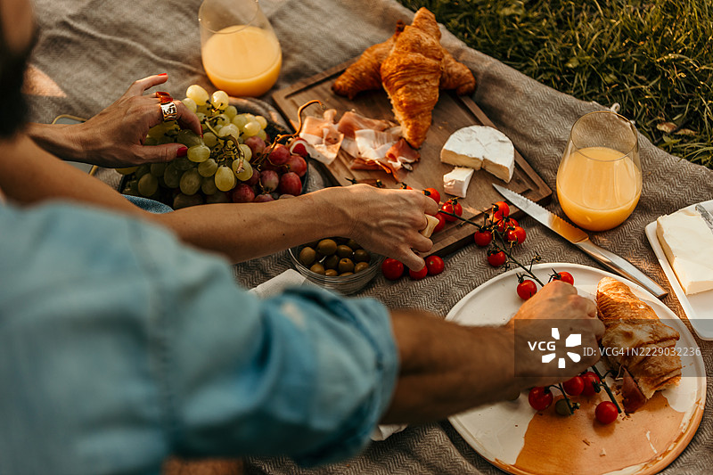 一对情侣在公园里享受美味的野餐图片素材
