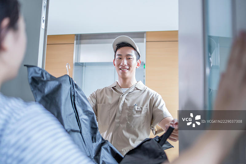 快递员将包裹递交给顾客图片素材