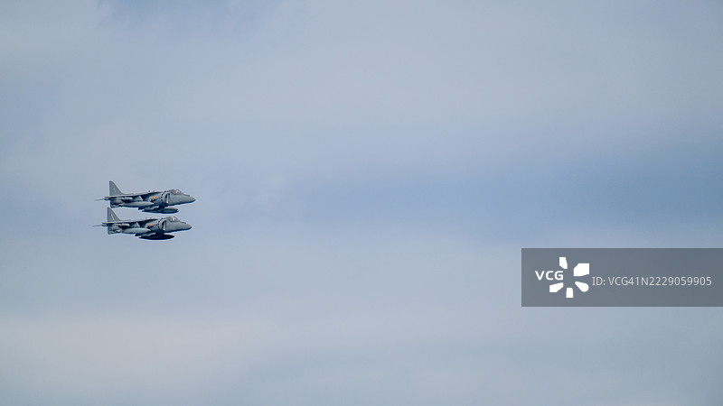 两架西班牙海军AV-8B鹞式II型军用飞机在多云的天空中飞行图片素材