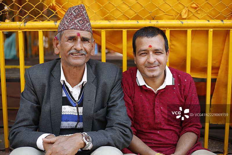 朝圣者在尼泊尔加德满都的布达尼尔坎塔寺参加布拉塔班达仪式（也称为乌帕那亚那）时摆姿势拍照。图片素材