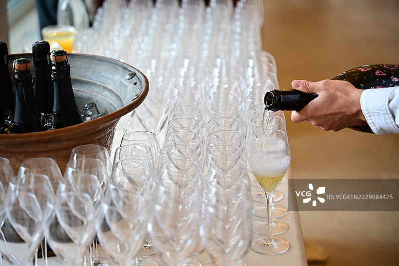 一名男子在活动中倒香槟的特写镜头图片素材