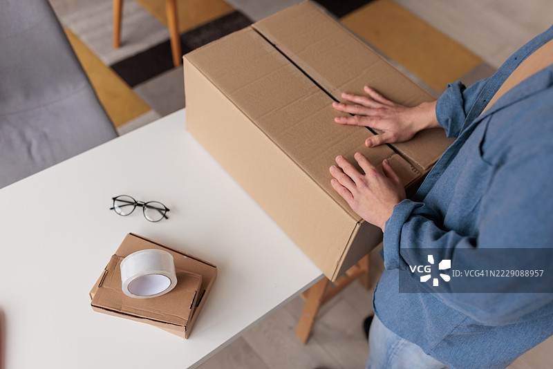 男人在触手可及的地方用胶带封闭盒子图片素材