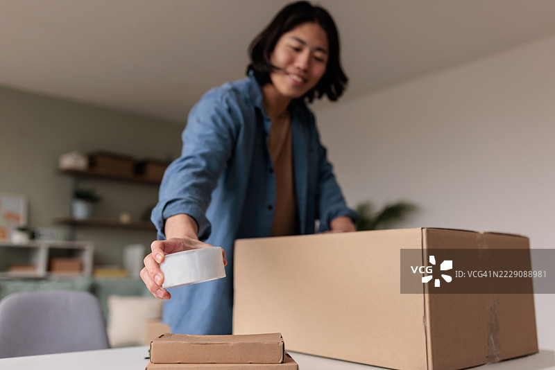 男子准备用胶带封闭纸箱图片素材