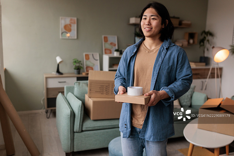 日本男子在一堆箱子中搬动一个小纸箱图片素材