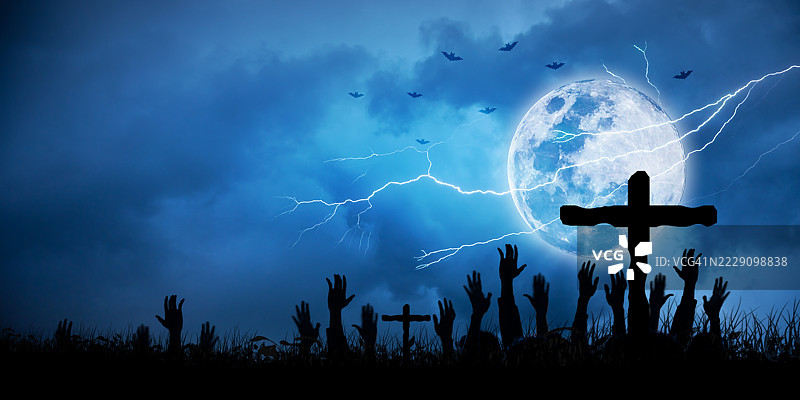 万圣节夜晚的墓地，僵尸之手在满月和闪电的恐怖背景下升起。墓地中的僵尸之手在万圣节夜晚的满月和蝙蝠中升起。阴森的墓地场景，雷声伴随月光，营造出万圣节的恐怖氛围。图片素材
